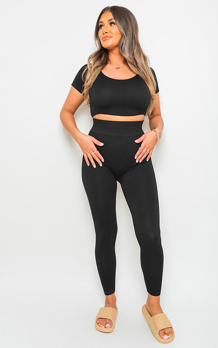 Woman wearing Ezra Short Sleeve Crop Top Leggings Co-ord Set, highlighting the chic crop top and form-fitting leggings, paired with casual slippers.