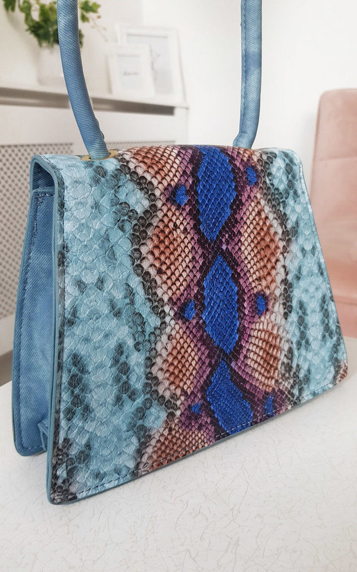 Croc Print Shoulder Handbag featuring a blue and pink snakeskin pattern with denim material, shoulder strap, and button fastening, perfect for stylish holiday outings.