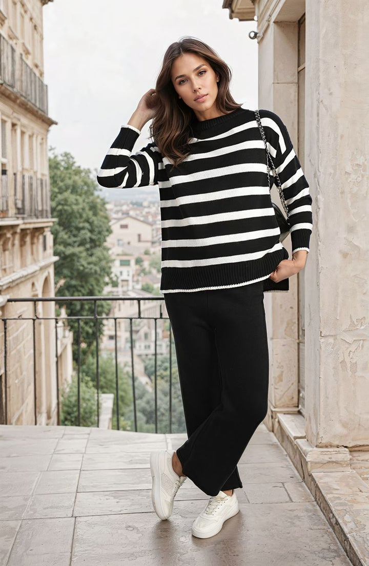 Woman wearing a Knitted Striped Long Sleeve Top and Pants Co-ord Set on a balcony, showcasing relaxed, stylish fashion suitable for casual outings or lounging.