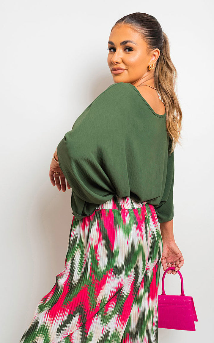 Woman in oversized batwing sleeve casual top, paired with a colorful skirt, showcasing a relaxed, stylish look. Perfect for everyday UK fashion from Holiday Clothes UK.