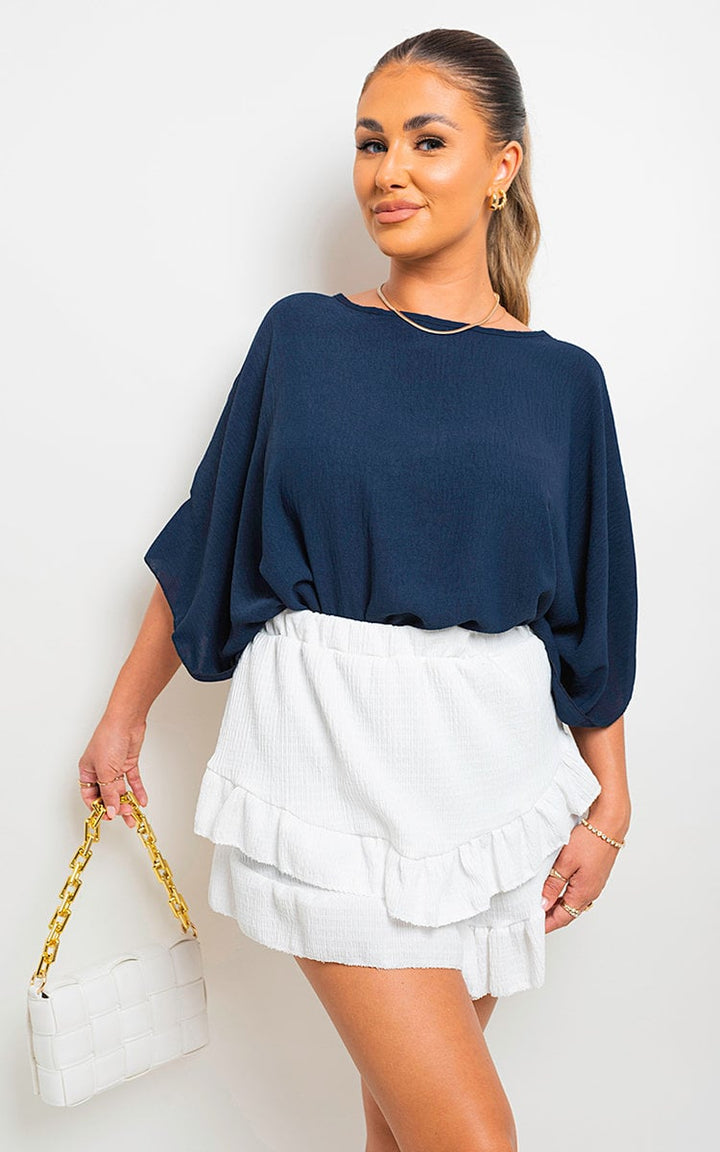 Woman holding Oversized Batwing Sleeve Casual Top, showcasing its relaxed, stylish design and unique batwing sleeves, ideal for casual, everyday wear.