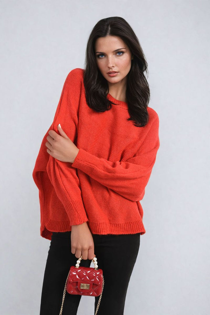 Woman wearing the Florencia Crew Neck Back Patterned Knitted Jumper, holding a red purse, showcasing the jumper's cozy fit and unique back pattern.