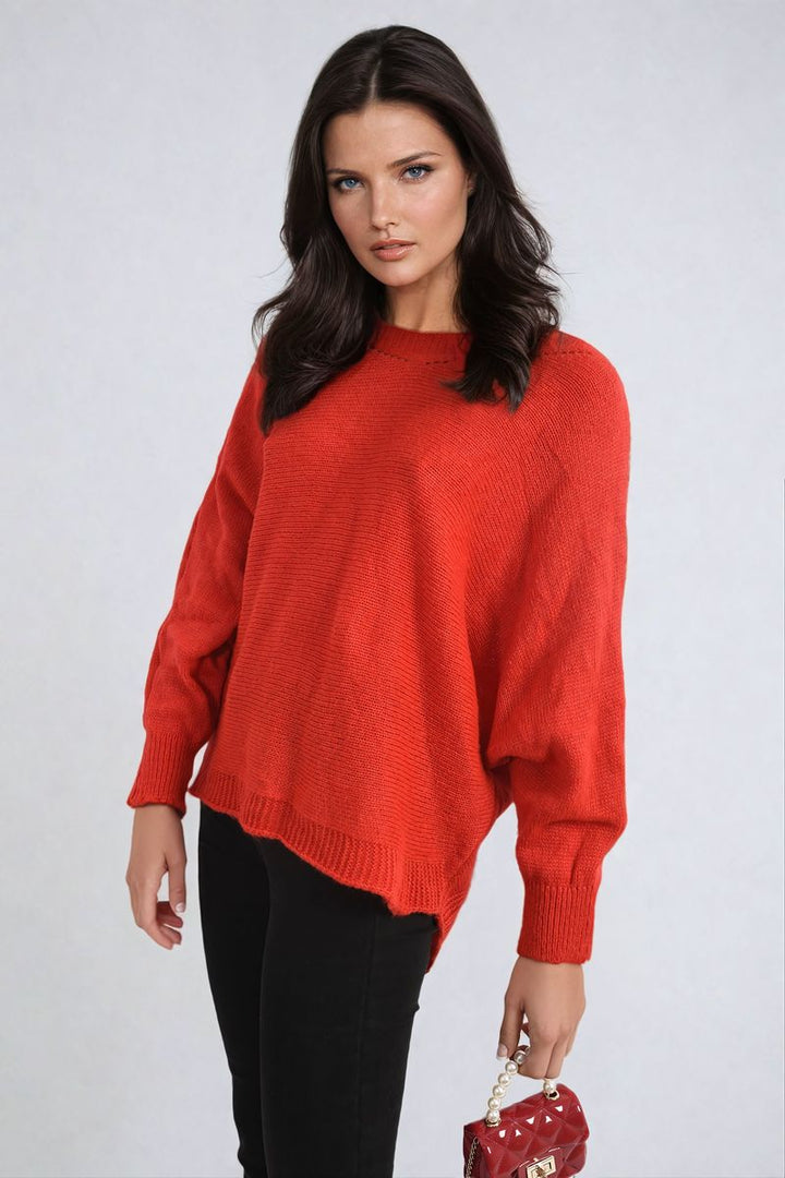 Woman in a red Crew Neck Back Patterned Knitted Jumper, holding a pearl necklace, highlighting the jumper's unique back pattern and cozy style.