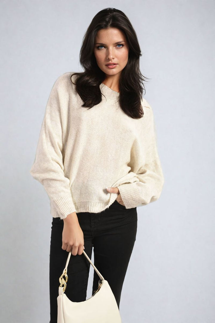 Woman wearing a Florencia Crew Neck Back Patterned Knitted Jumper, holding a white purse, highlighting the jumper's stylish design and cozy appeal.