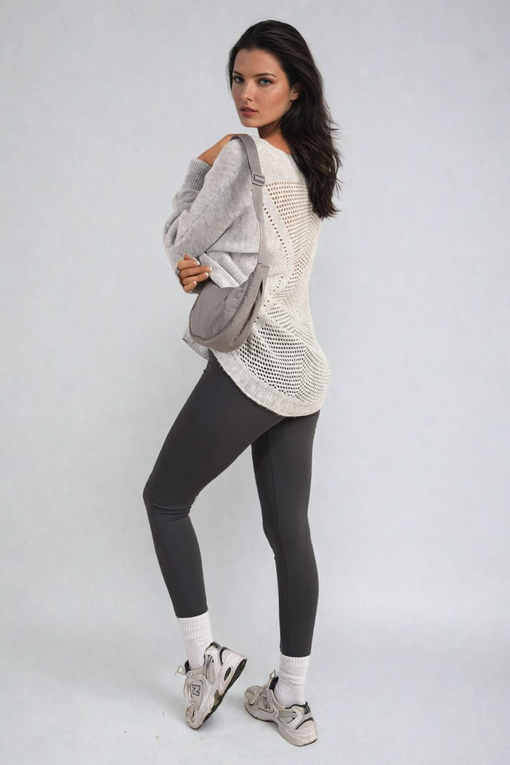 Woman wearing the Florencia Crew Neck Back Patterned Knitted Jumper with grey leggings and white shoes, showcasing a stylish and cozy look for casual outings.