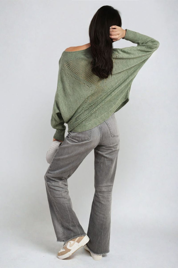 Woman wearing the Florencia Crew Neck Back Patterned Knitted Jumper, paired with grey pants, showcasing the jumper's unique back design for casual style.