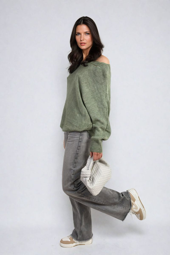 Woman wearing Crew Neck Back Patterned Knitted Jumper, holding a white purse, paired with grey jeans and boots. Perfect for casual, stylish outings.