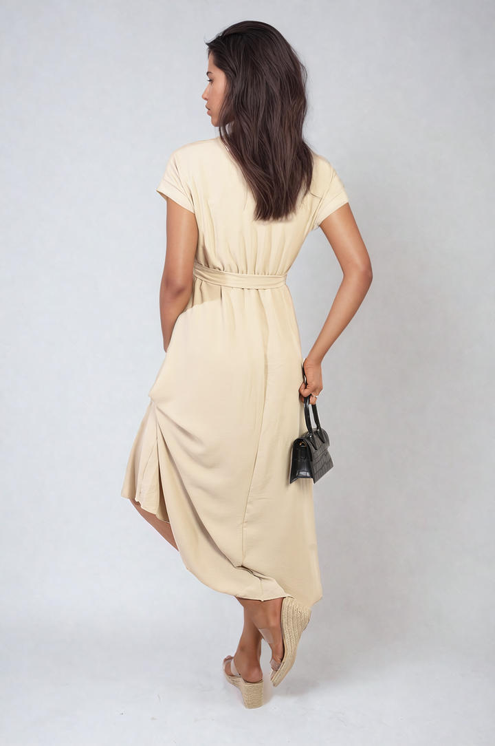 Woman in a wrap tie waist short sleeve midi dress holding a black bag, showcasing its flattering silhouette and versatile style.