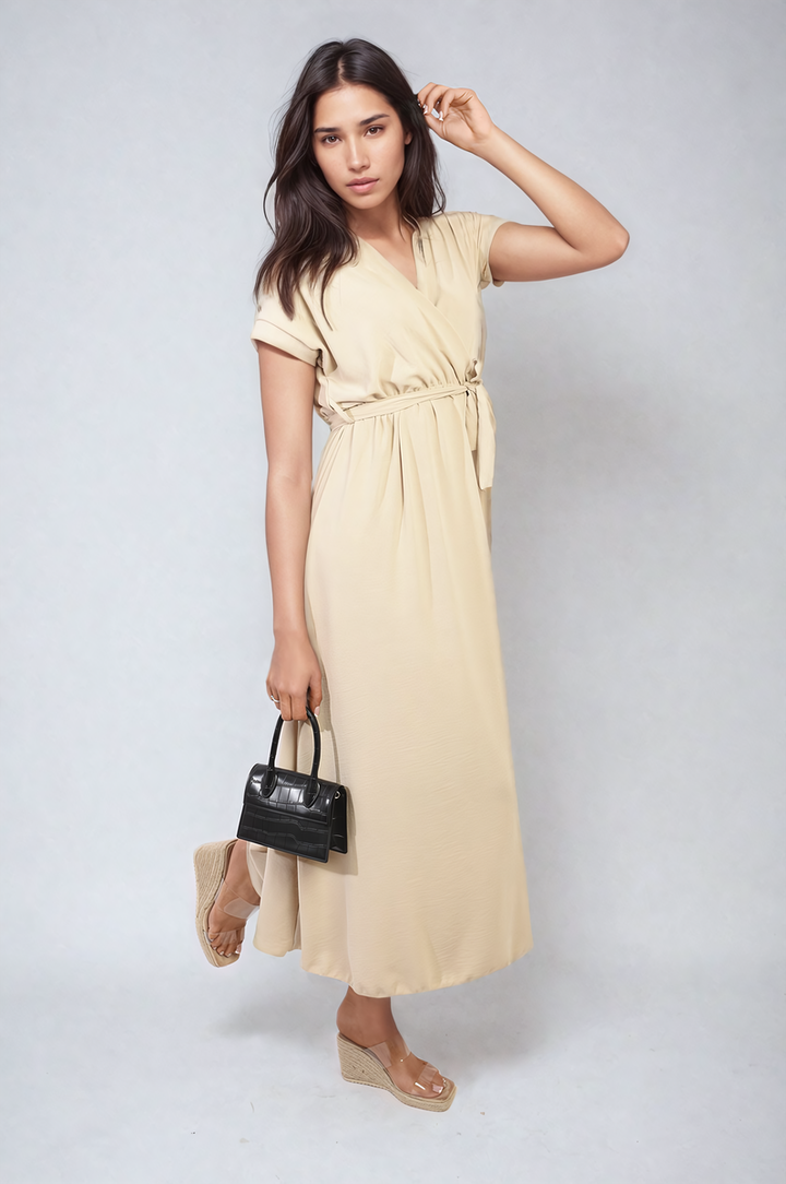 Woman in a wrap tie waist short sleeve midi dress holding a purse, showcasing elegant and versatile fashion from Holiday Clothes UK.