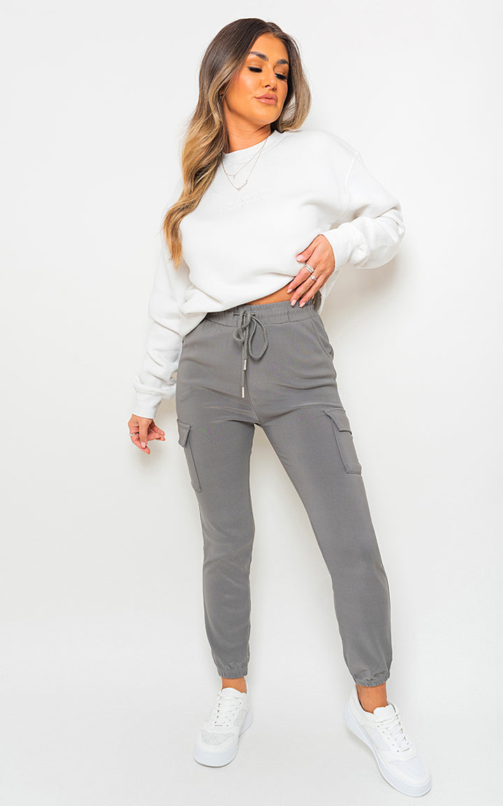 Woman wearing Fleece Lined Cargo Pocket Trouser with Drawstring, showcasing its stylish and functional design with visible cargo pockets and comfortable fit.