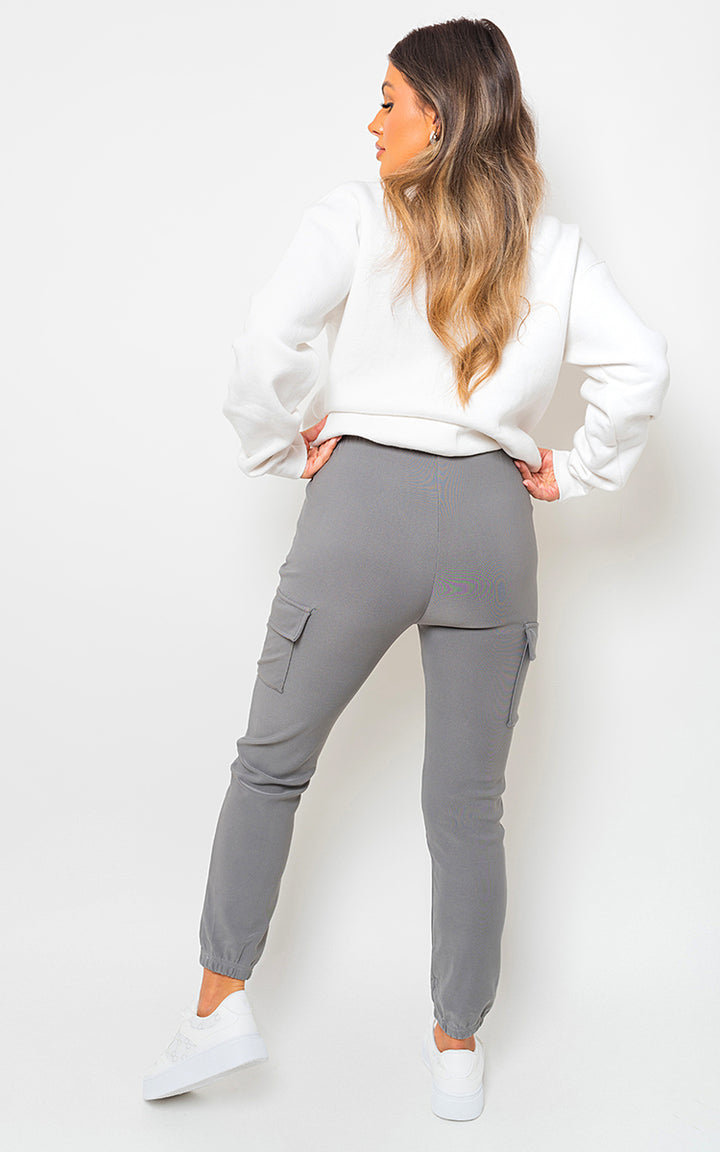 Fleece Lined Cargo Pocket Trouser with Drawstring, featuring a woman in white sweater and grey pants, showcasing trendy and functional design for stylish adventures.