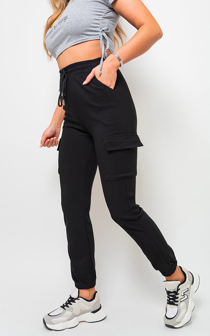 Woman wearing fleece lined cargo pocket trousers with drawstring, showcasing utility-chic style and functionality, ideal for stylish holiday or everyday adventures.