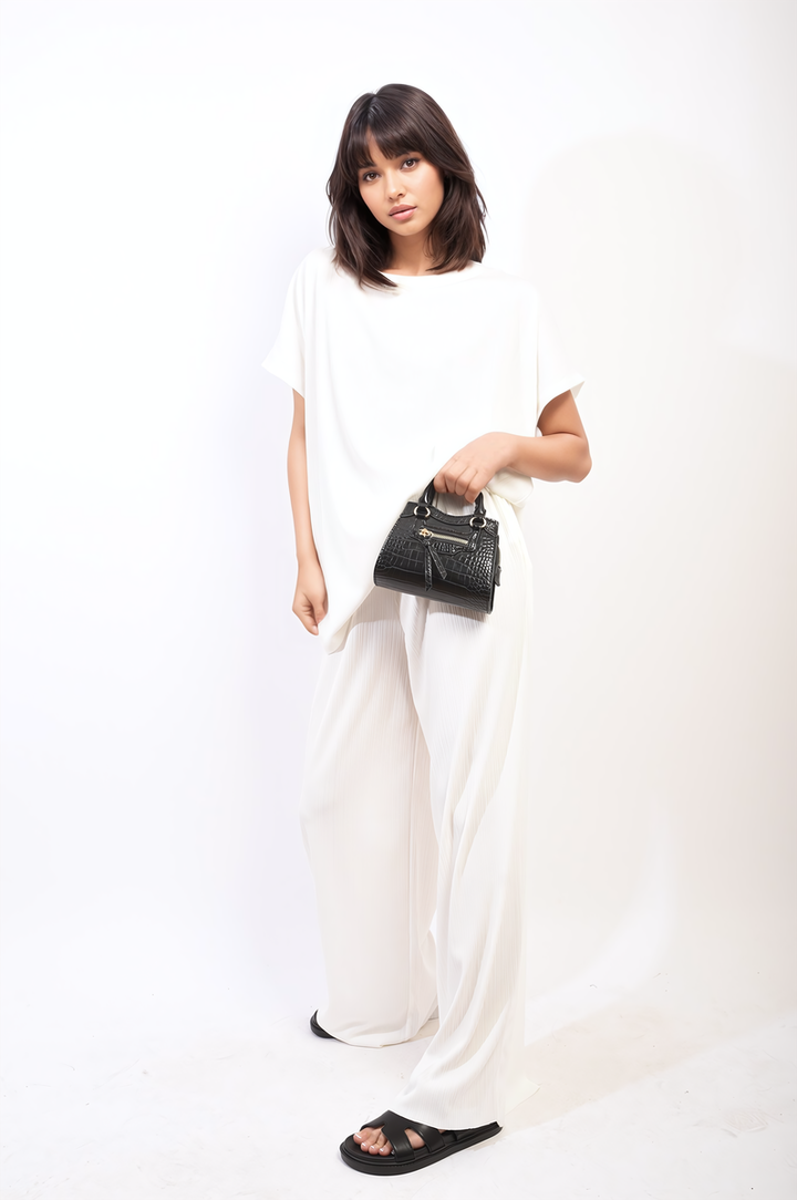 Woman holding a black purse, wearing the Gabriella Oversized Top and Wide Leg Trouser Co-ord Set, showcasing a chic and comfortable outfit from Holiday Clothes UK.