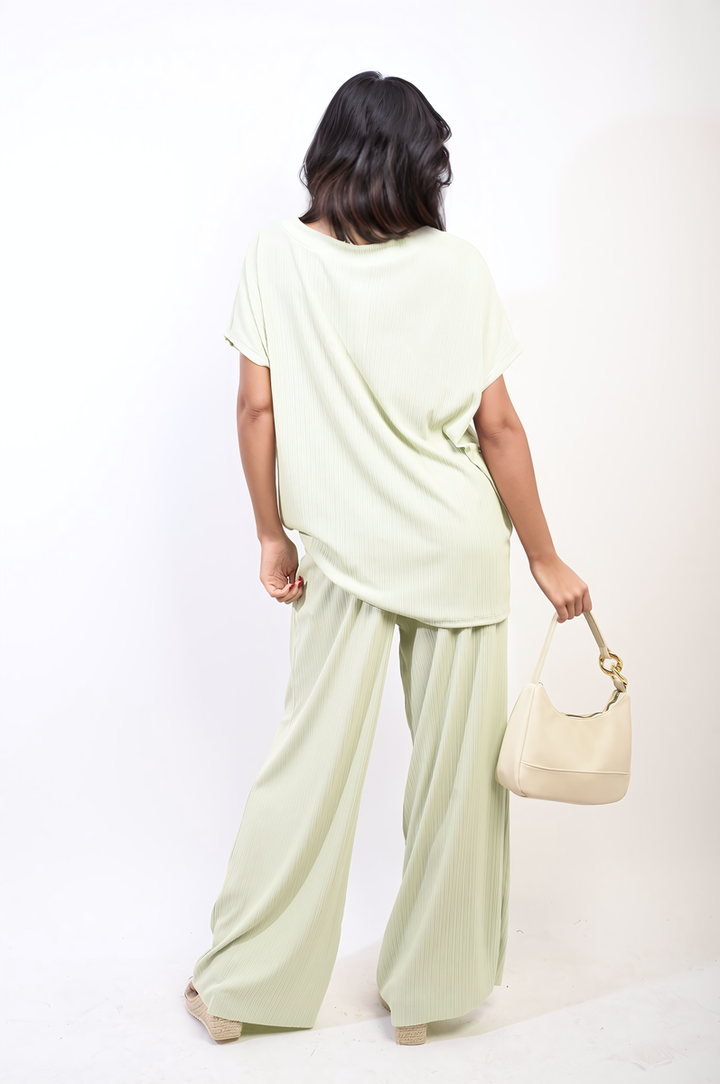 Woman wearing the Gabriella Oversized Top and Wide Leg Trouser Co-ord Set, showcasing relaxed, stylish fit, paired with a white purse and casual footwear.