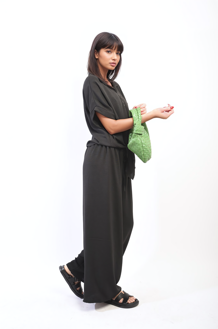 Woman wearing the Gabriella Oversized Top and Wide Leg Trouser Co-ord Set, holding a green purse, showcasing a relaxed, stylish outfit from Holiday Clothes UK.