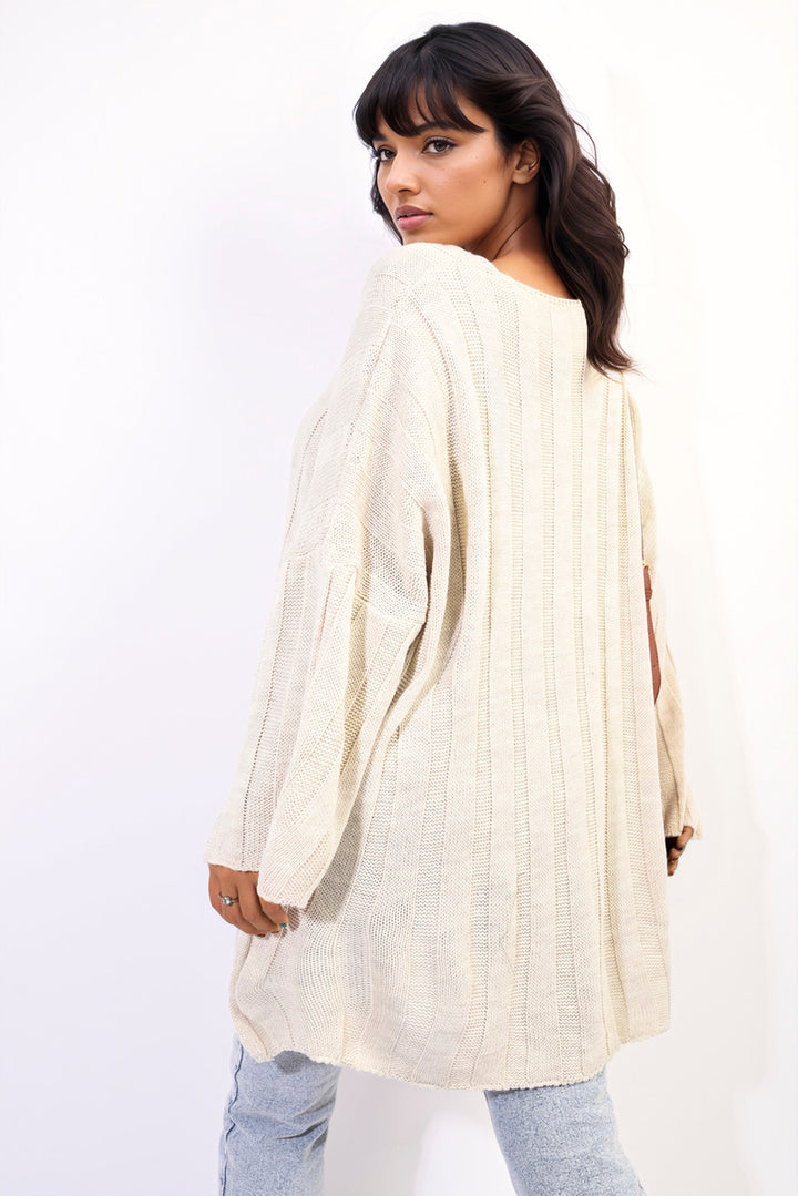 Woman in a white oversized knitted jumper, showcasing its cozy and stylish design, perfect for casual and trendy winter wear.