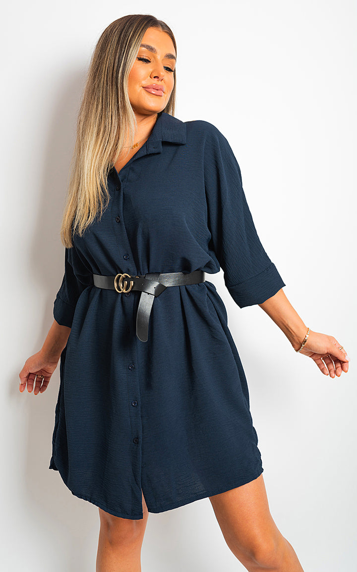 Woman wearing the Georgia Collared Button Down Mini Dress with a black belt, showcasing an elegant A-line silhouette and collared neckline, perfect for casual or chic occasions.