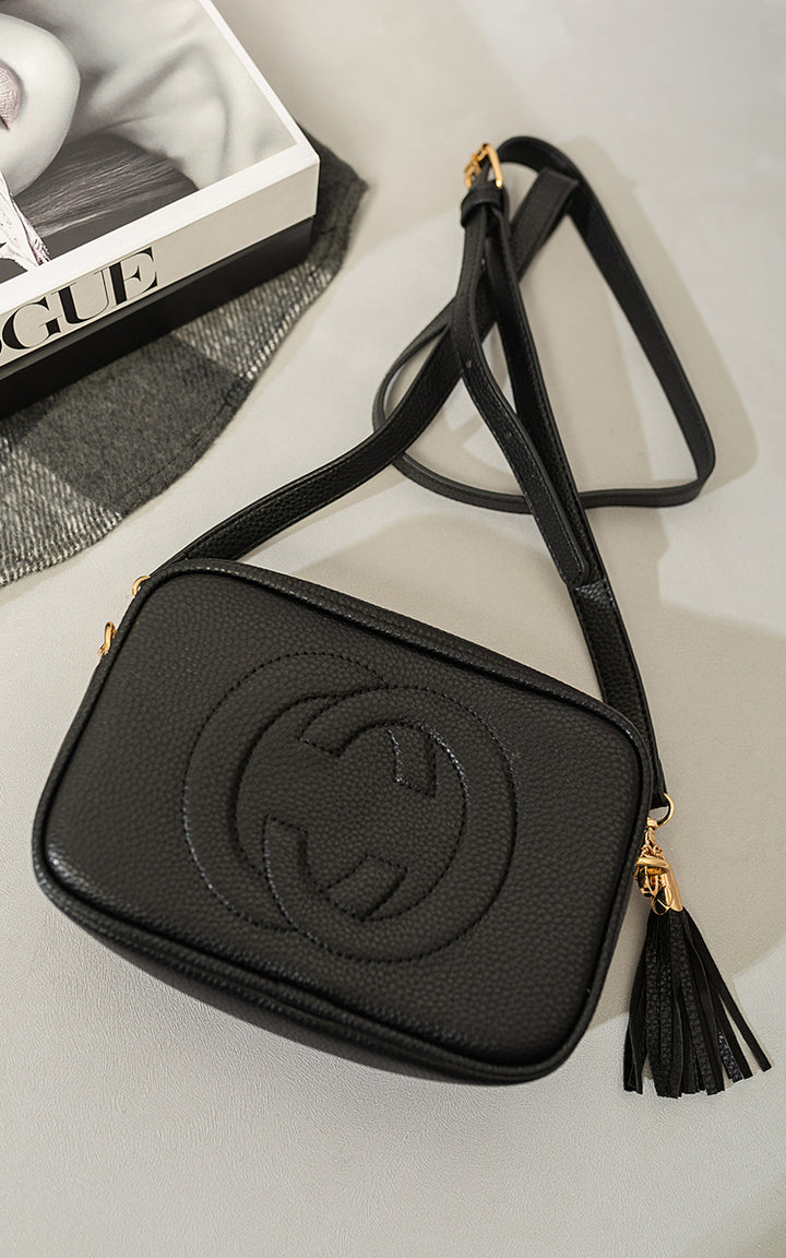 Leather Crossbody Bag with Tassel Detail, featuring a sleek design and adjustable strap, perfect for adding elegance to your accessory collection.