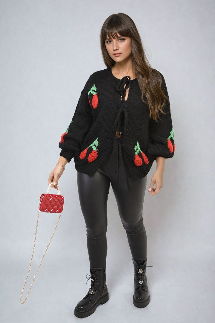 Tie Front Cherry Print Knitted Cardigan with playful cherry design and tie front, worn by a woman, showcasing a stylish and cozy addition to your wardrobe.