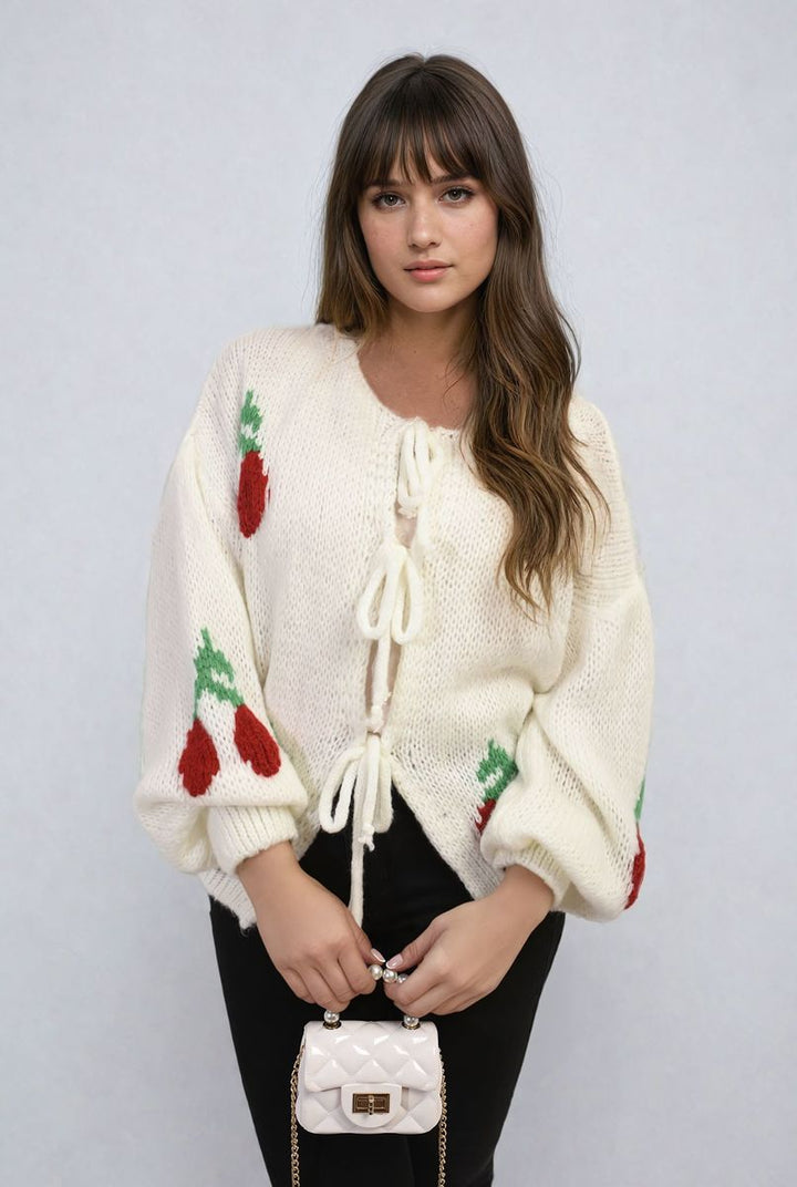 Woman wearing the Tie Front Cherry Print Knitted Cardigan, featuring a playful cherry design and tie front, perfect for adding whimsy to everyday outfits.