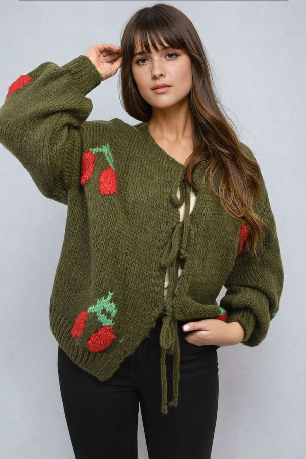 Woman wearing the Giselle Tie Front Cherry Print Knitted Cardigan, featuring a tie front and cherry print, posing for a stylish fashion photo.