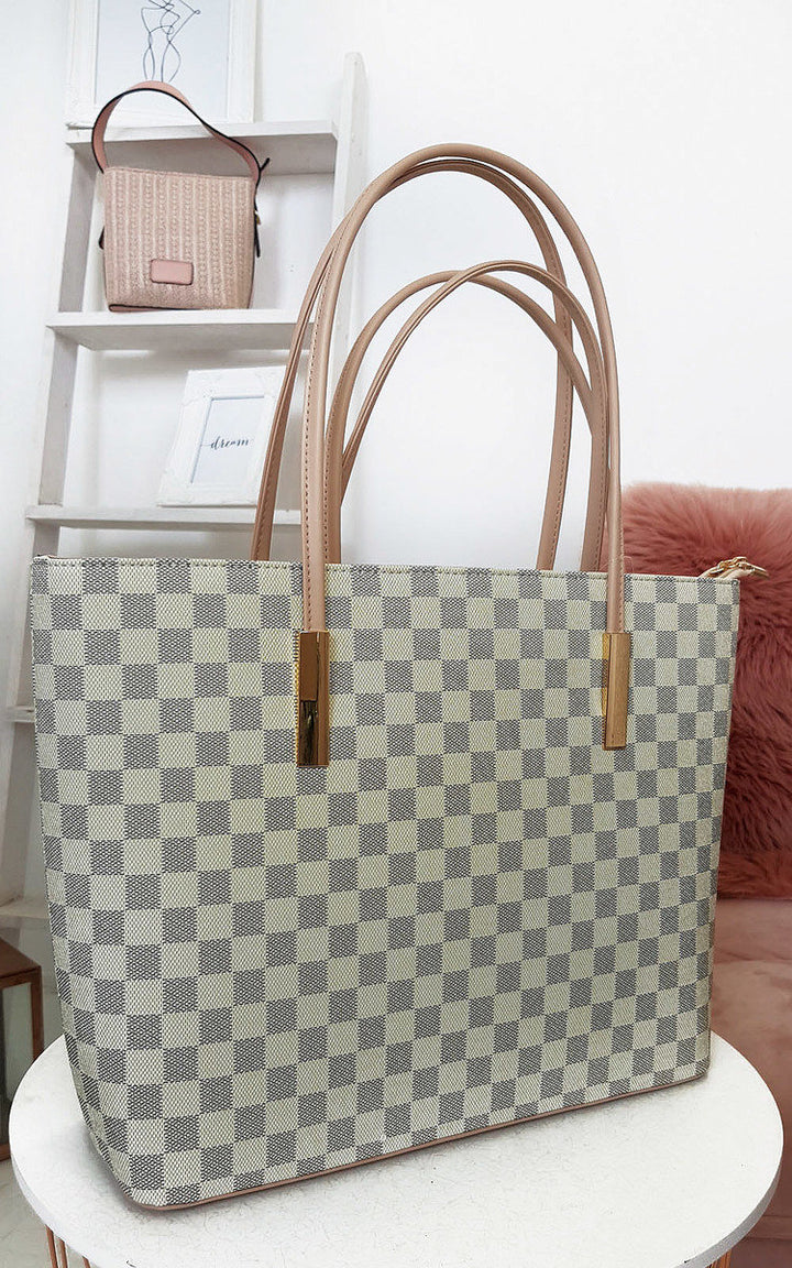 Checked Two in One Handbag on a shelf, featuring a checked print with zip closure and detachable inner bag, ideal for versatile day-to-night use.