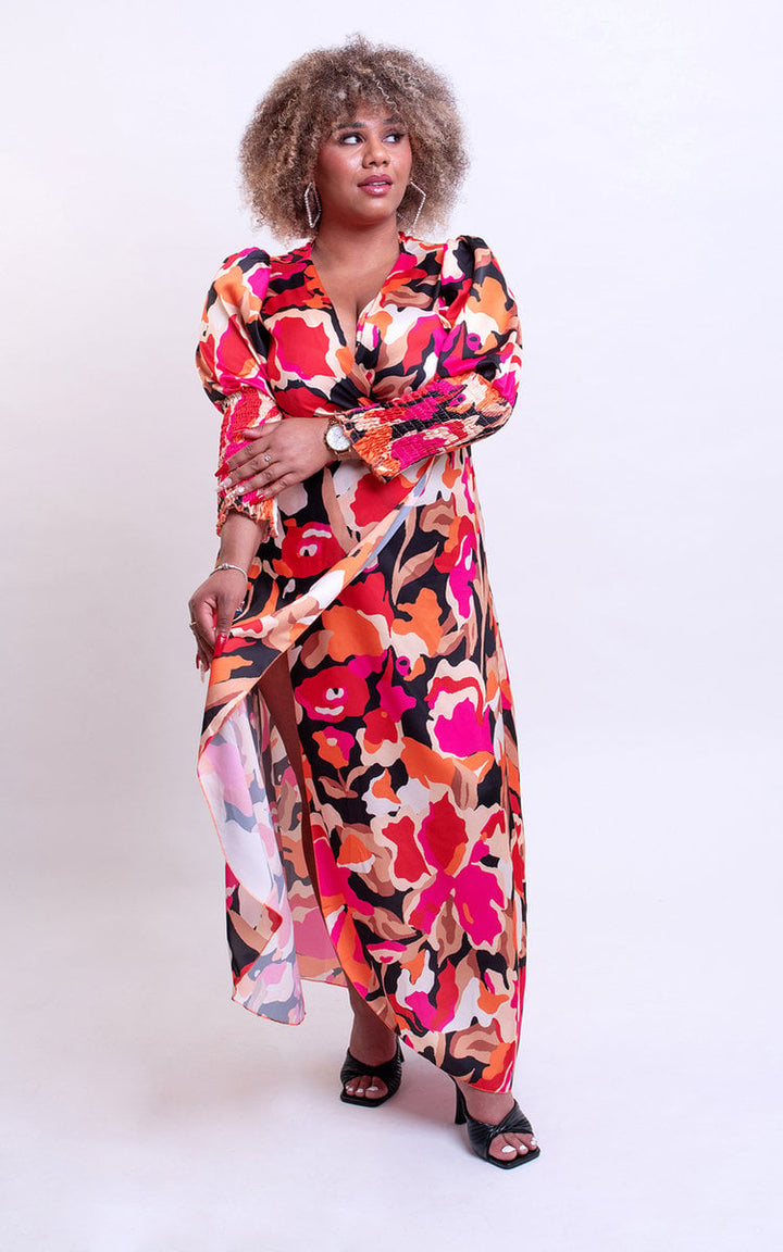 Wrap Front Printed Midi Dress featuring a floral pattern, worn by a woman with curly hair, showcasing its flattering silhouette and versatile style.