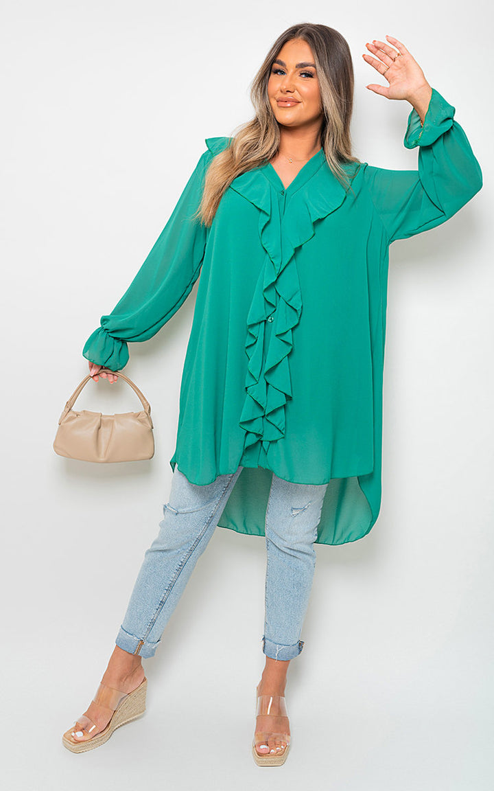 Woman showcasing Oversized Ruffle Long Sleeve Tops, featuring stylish ruffle sleeves, paired with blue jeans and a tan purse in a casual pose.