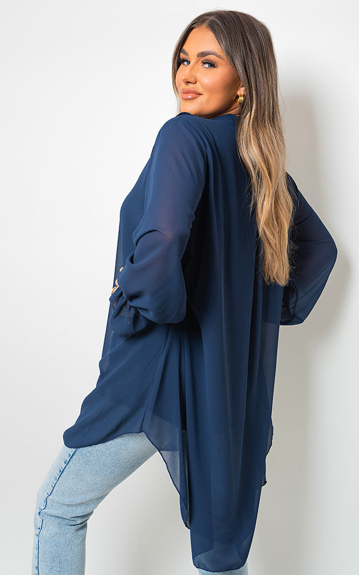 Woman wearing an Oversized Ruffle Long Sleeve Top, showcasing relaxed fit and ruffle sleeve details, highlighting comfort and style from Holiday Clothes UK.