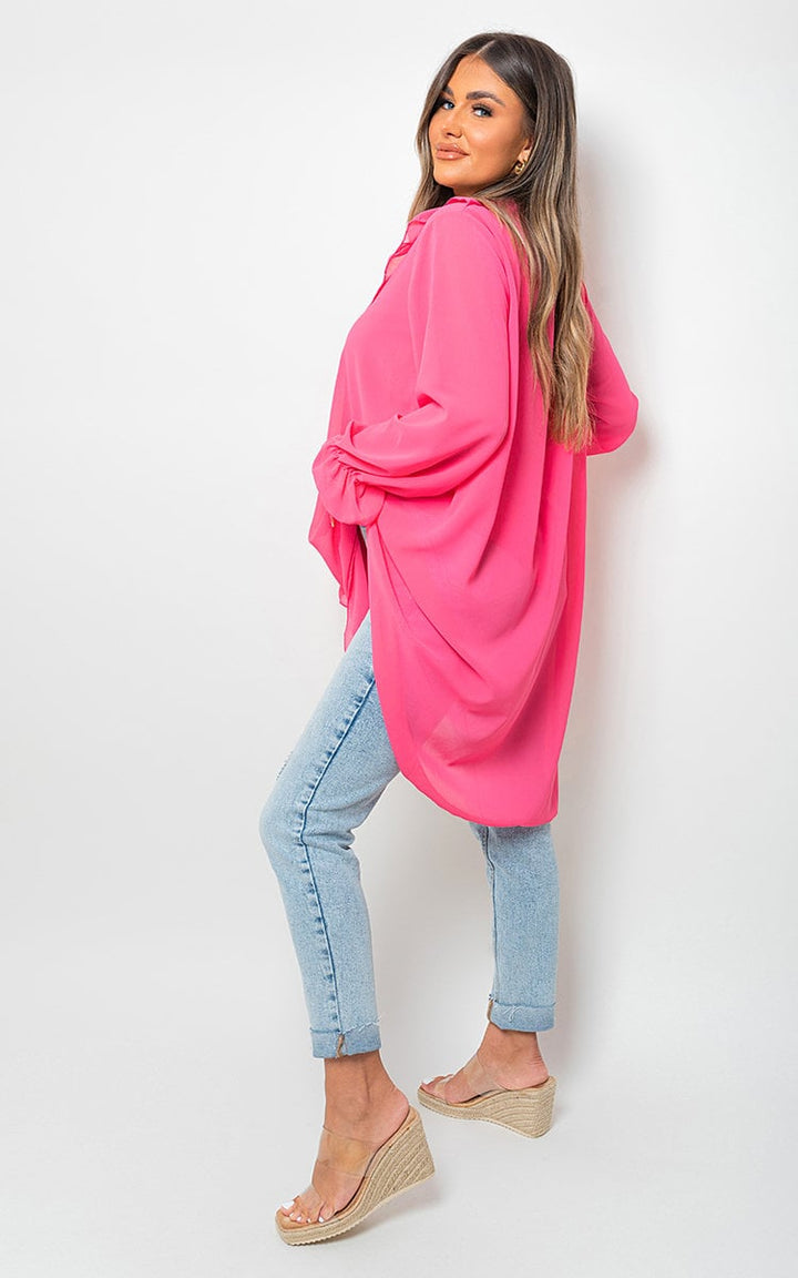 Woman wearing Oversized Ruffle Long Sleeve Top, showcasing its relaxed fit and ruffle detailing, perfect for stylish and comfortable everyday wear.