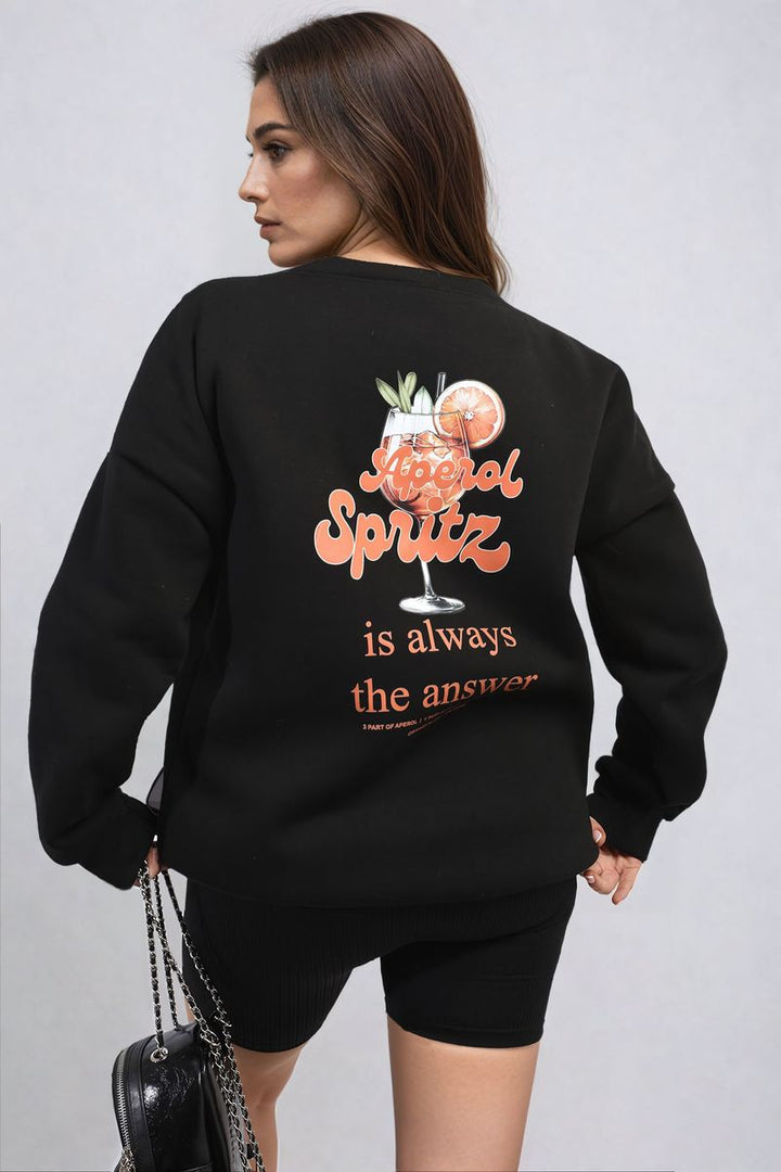 Woman wearing the Helen Aperol Spritz Cocktail Graphic Knitted Jumper, featuring a playful cocktail graphic for a cozy, stylish look. Perfect for casual, chic outfits.