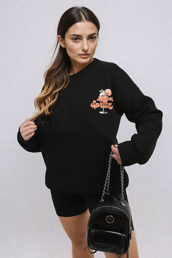 Woman wearing the Helen Aperol Spritz Cocktail Graphic Knitted Jumper, holding a purse, showcasing a playful and cozy style from Holiday-clothes.co.uk.