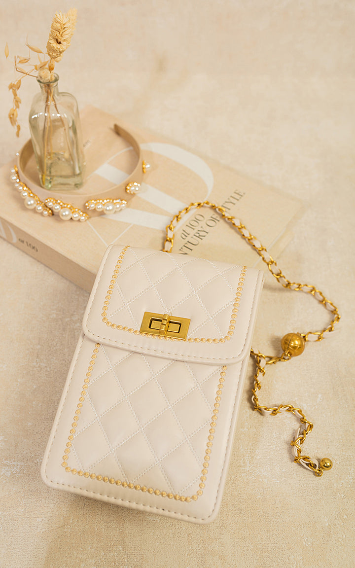 Quilted Crossbody Chain Shoulder Mini Bag with gold studs and chain strap, displayed on a book, alongside a necklace.