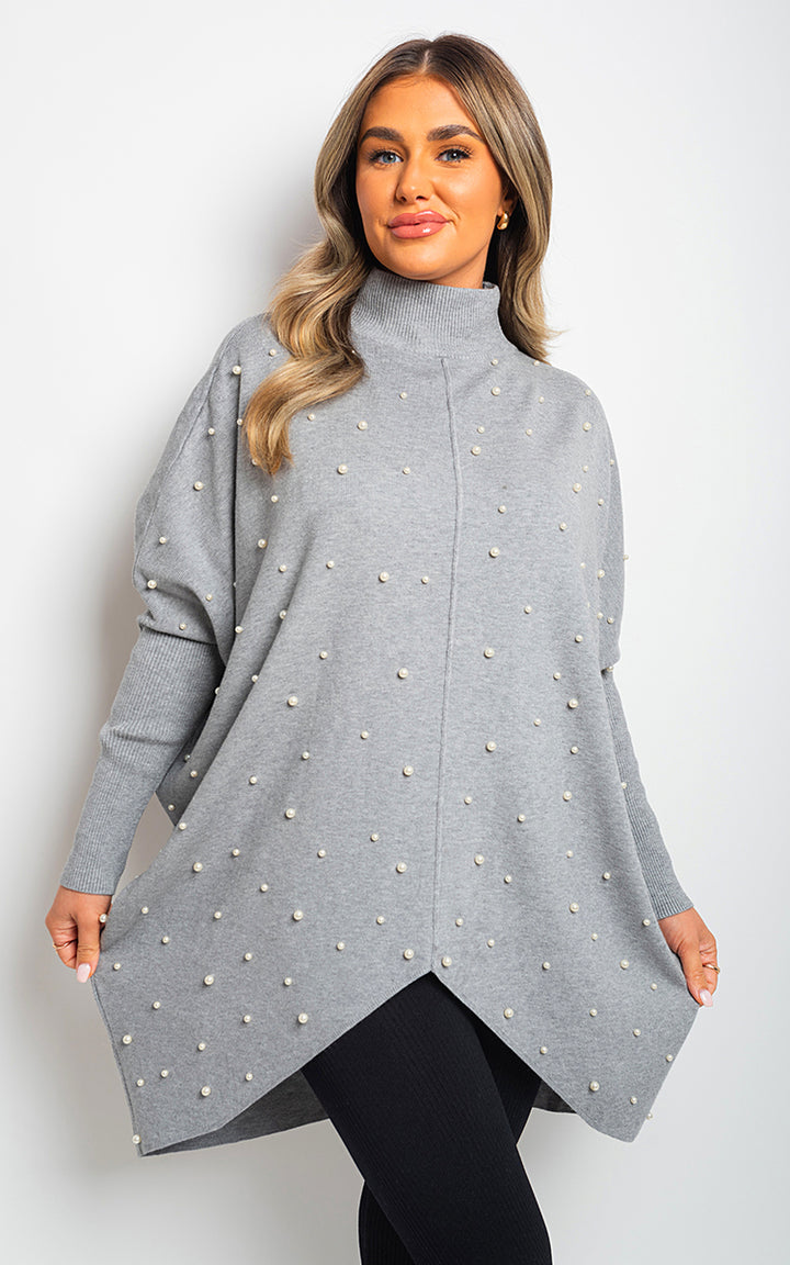 Woman wearing Ingrid Oversized Pearl Knitted Jumper, showcasing its relaxed fit and hand-stitched pearl details, perfect for stylish comfort.