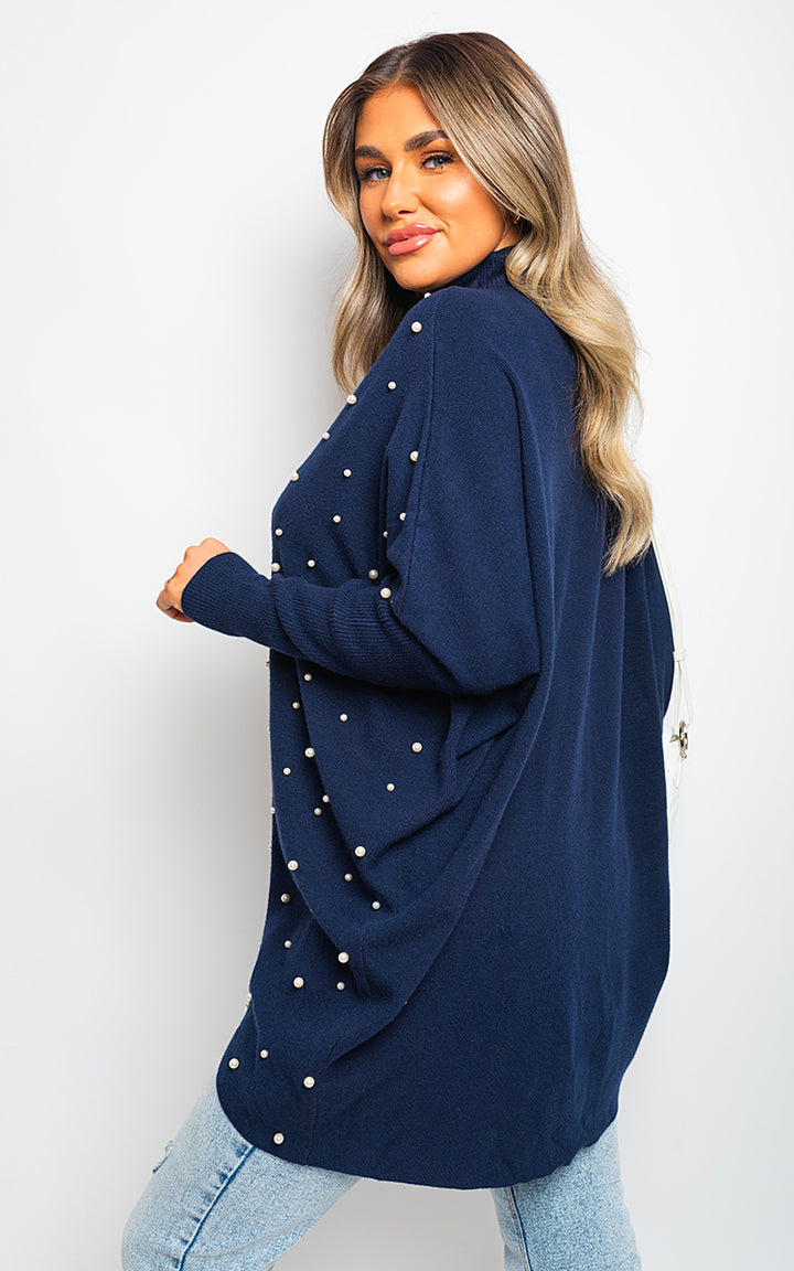 Woman wearing Ingrid Oversized Pearl Knitted Jumper, showcasing hand-stitched pearl detailing and relaxed fit, ideal for stylish comfort from Holiday Clothes UK.