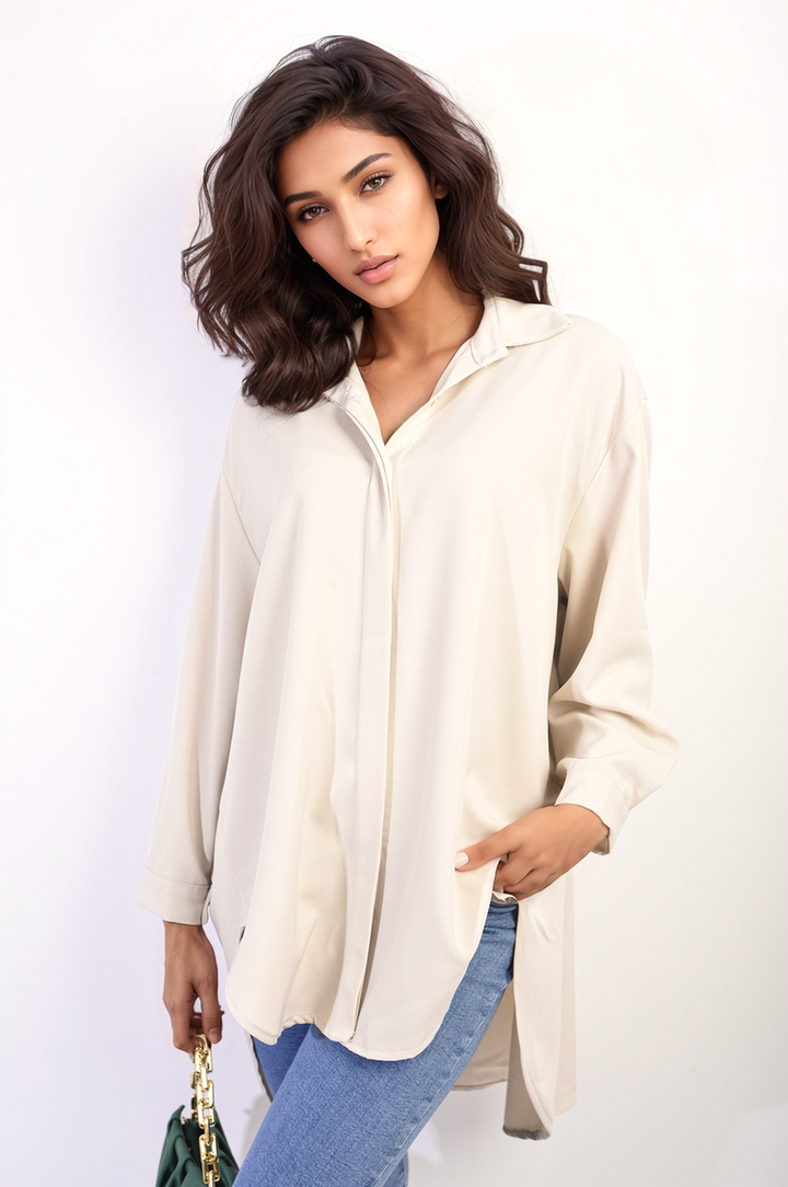 Woman wearing the Isabella Button Up Oversized Long Back Shirt Dress, featuring a relaxed fit and distinctive long back hemline, posing indoors.