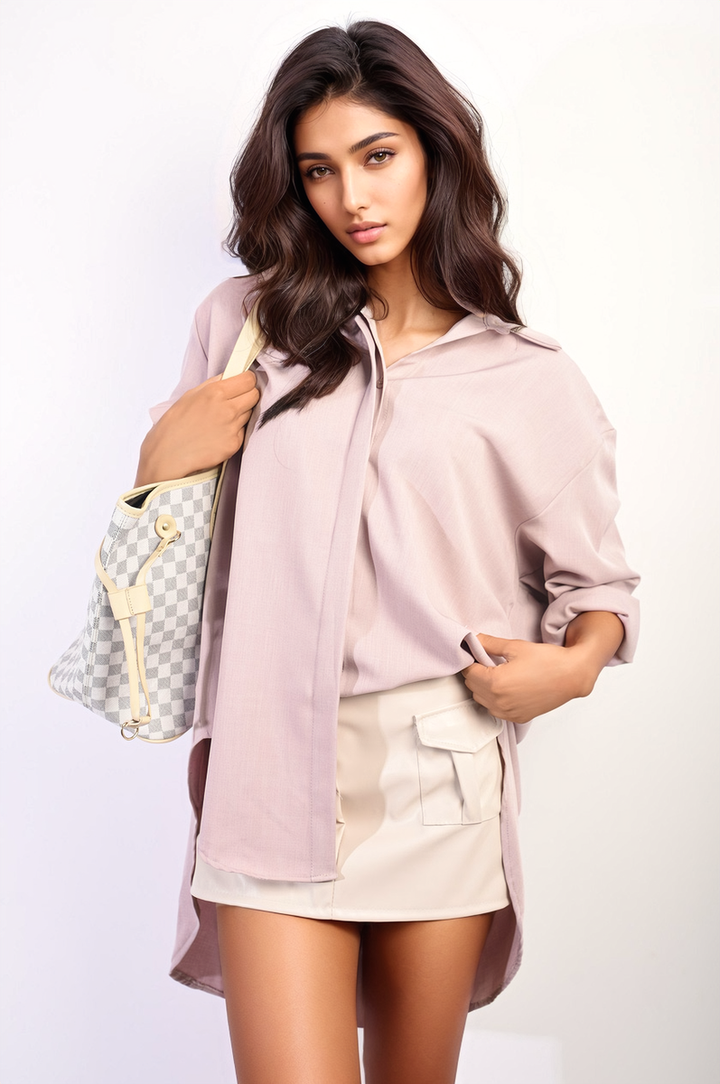 Woman holding a purse, showcasing the Isabella Button Up Oversized Long Back Shirt Dress, highlighting its unique long back hemline and relaxed fit.