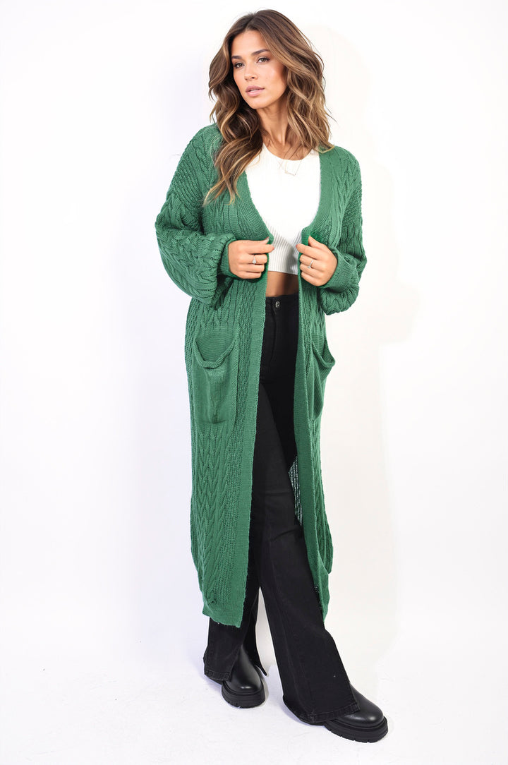 Woman wearing a Front Open Long Knitted Cardigan with Front Pockets, styled with black boots, showcasing a cozy, chic design perfect for everyday wear.