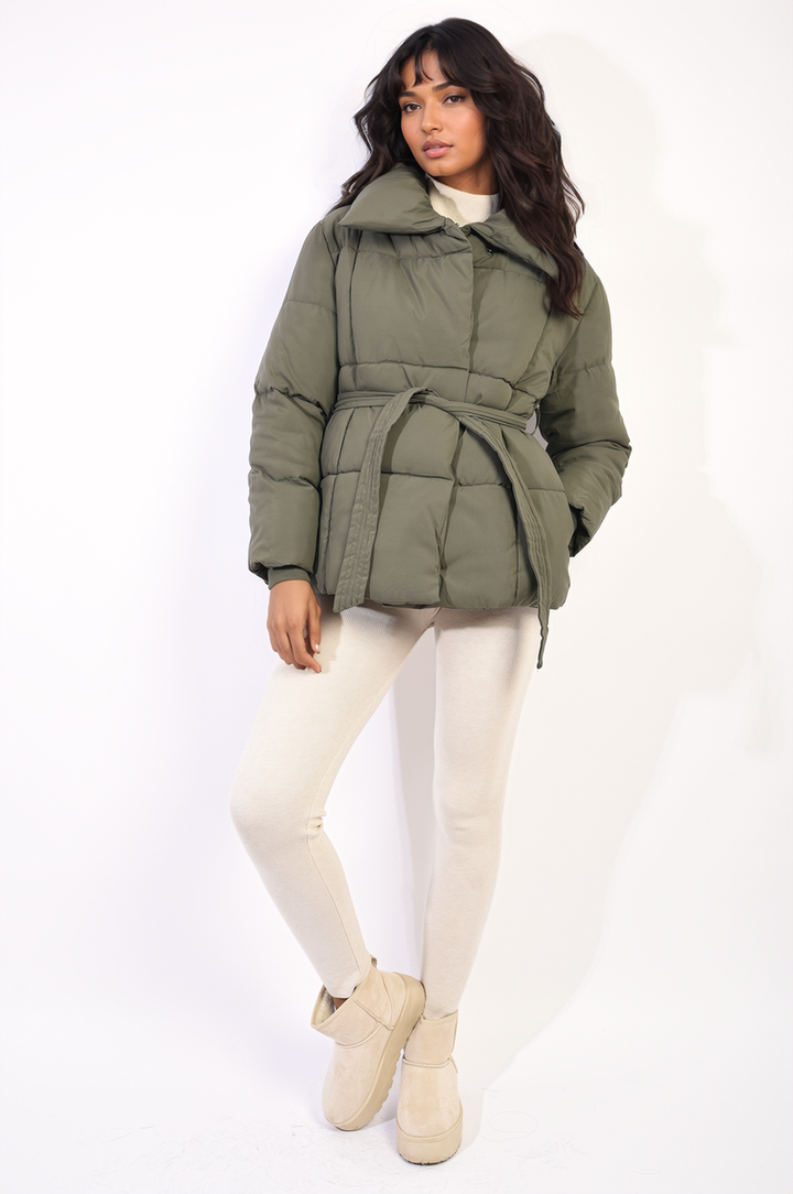 Woman wearing the Quilted Padded Puffer Jacket With Belt Detail, showcasing its quilted design and elegant belt feature for stylish warmth.