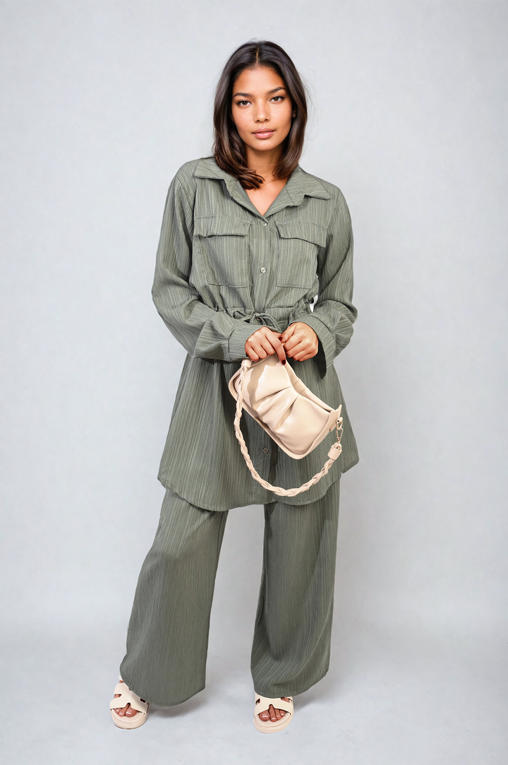 Woman holding a white purse, wearing the Oversized Long Sleeve Belted Button Down Top and Trouser Co-ord Set, showcasing stylish holiday clothing essentials.