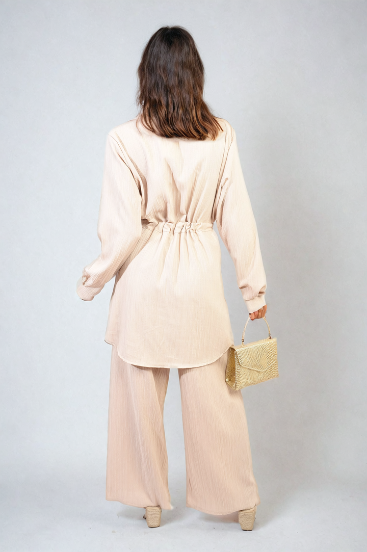 Woman wearing Oversized Long Sleeve Belted Button Down Top and Trouser Co-ord Set, showcasing the outfit's chic, relaxed fit and stylish design features.