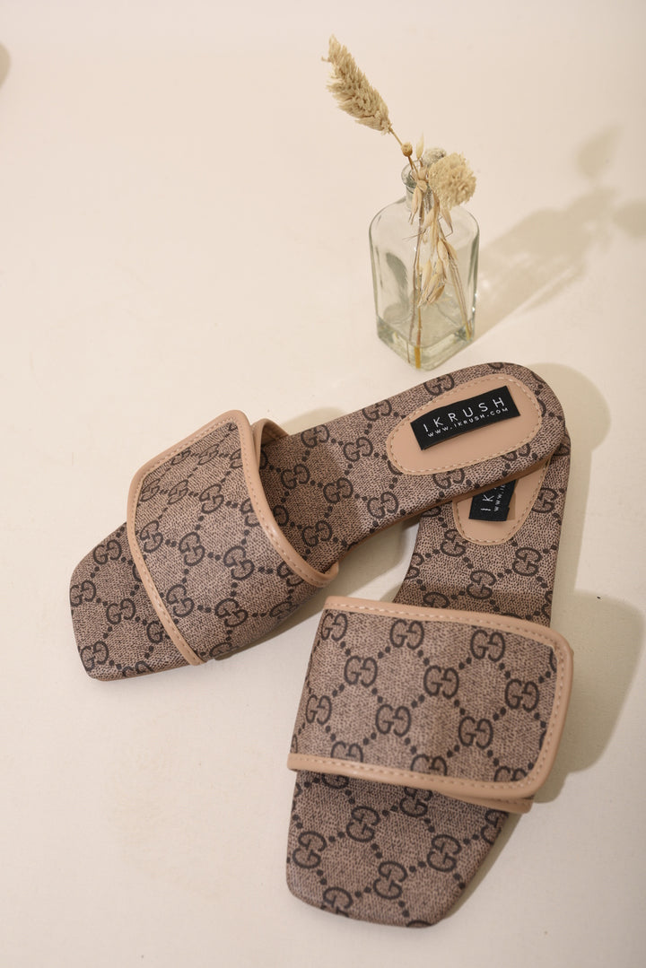 Patterned Front Strap Flat Sandals on a table, featuring a stylish patterned strap, ideal for summer outings with chic and comfortable design.