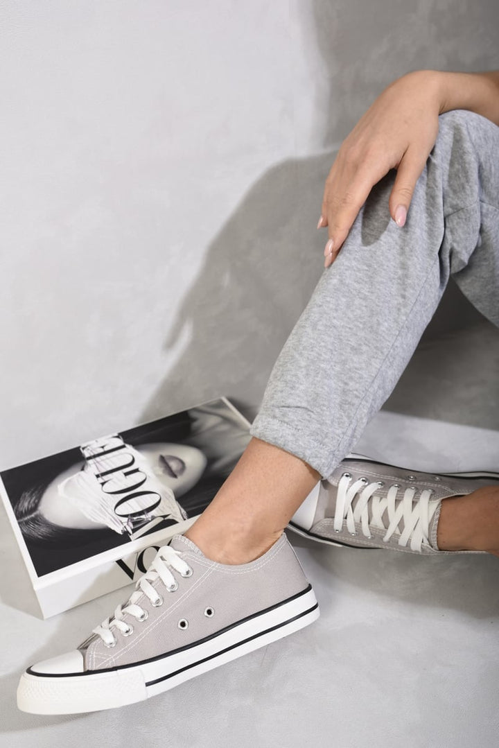 Person wearing Jenna Platform Low Top Lace Up Trainers, showcasing a stylish, comfortable fit with white laces and platform sole, ideal for casual outfits.