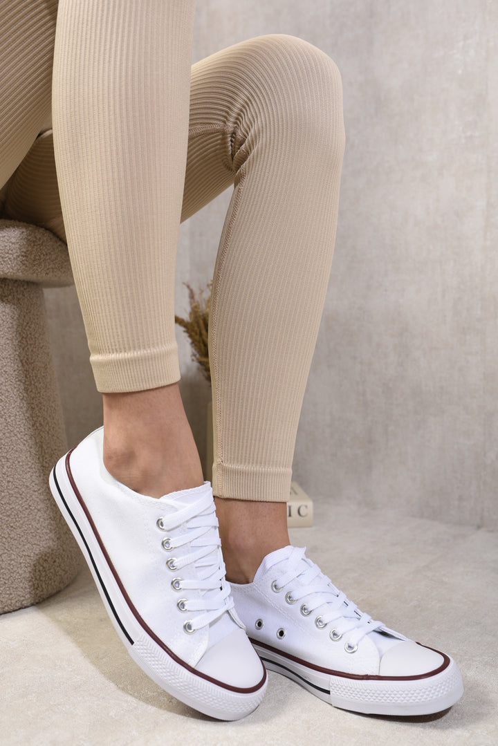 Person wearing Jenna Platform Low Top Lace Up Trainers, showcasing their stylish low-top design and platform sole, perfect for casual outfits.