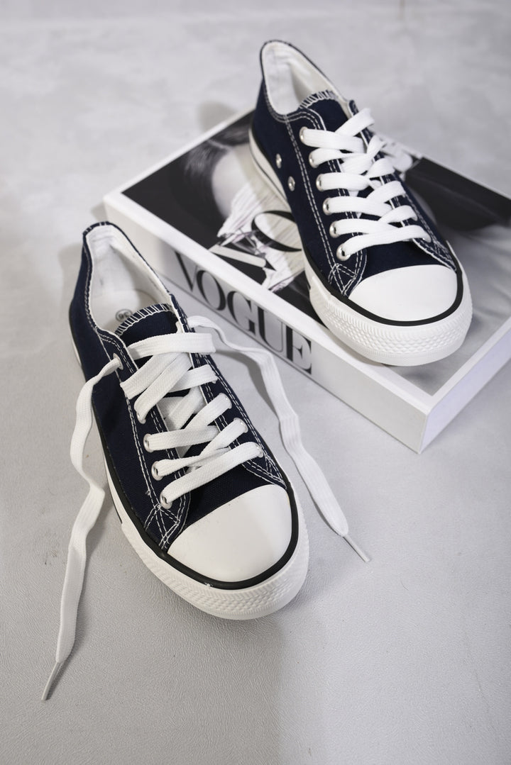 Platform Low Top Lace Up Trainers on a book, showcasing their chic design and lace-up closure for a secure fit.