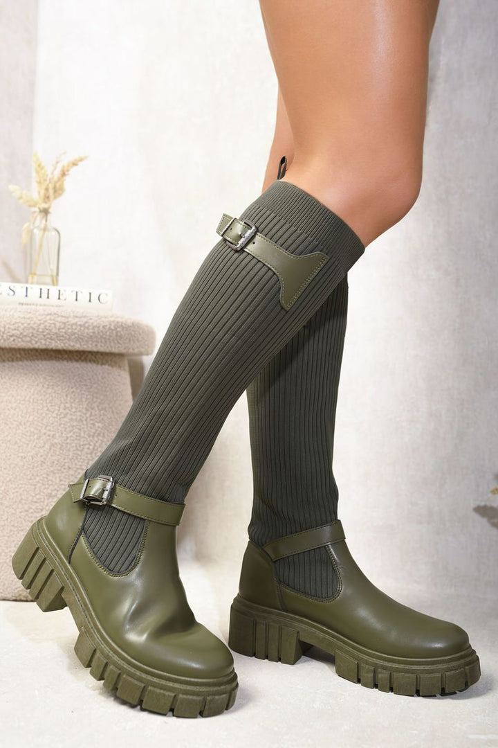 A person wearing the Jessica Stretch Knee High Chunky Sock Boots, showcasing their snug fit and chunky sole, perfect for stylish comfort on chilly days.