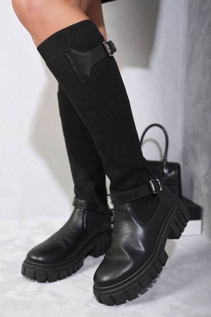 Person wearing Jessica Stretch Knee High Chunky Sock Boots, showcasing their snug fit and chunky sole, ideal for stylish comfort on chilly days.