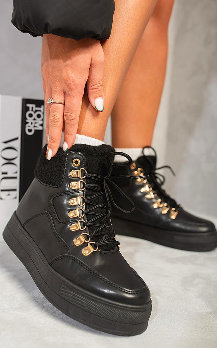 Person wearing Jillian Leather Lace Up Front Platform Boots, featuring gold laces and a platform heel, ideal for elevating fashion styles.