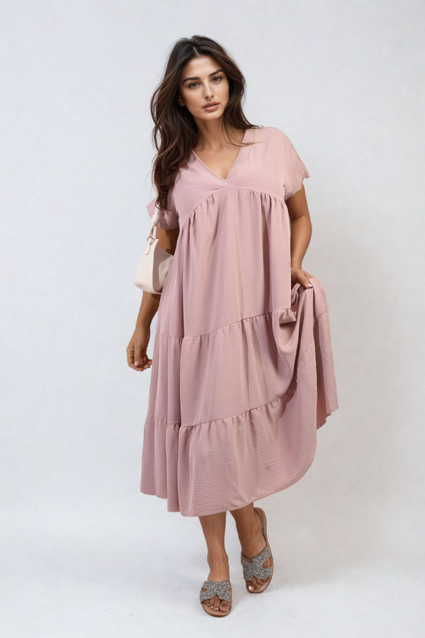 Woman in a Short Sleeve Tiered V-Neck Midi Dress, holding a white purse, showcasing a chic and versatile style perfect for casual outings or special occasions.