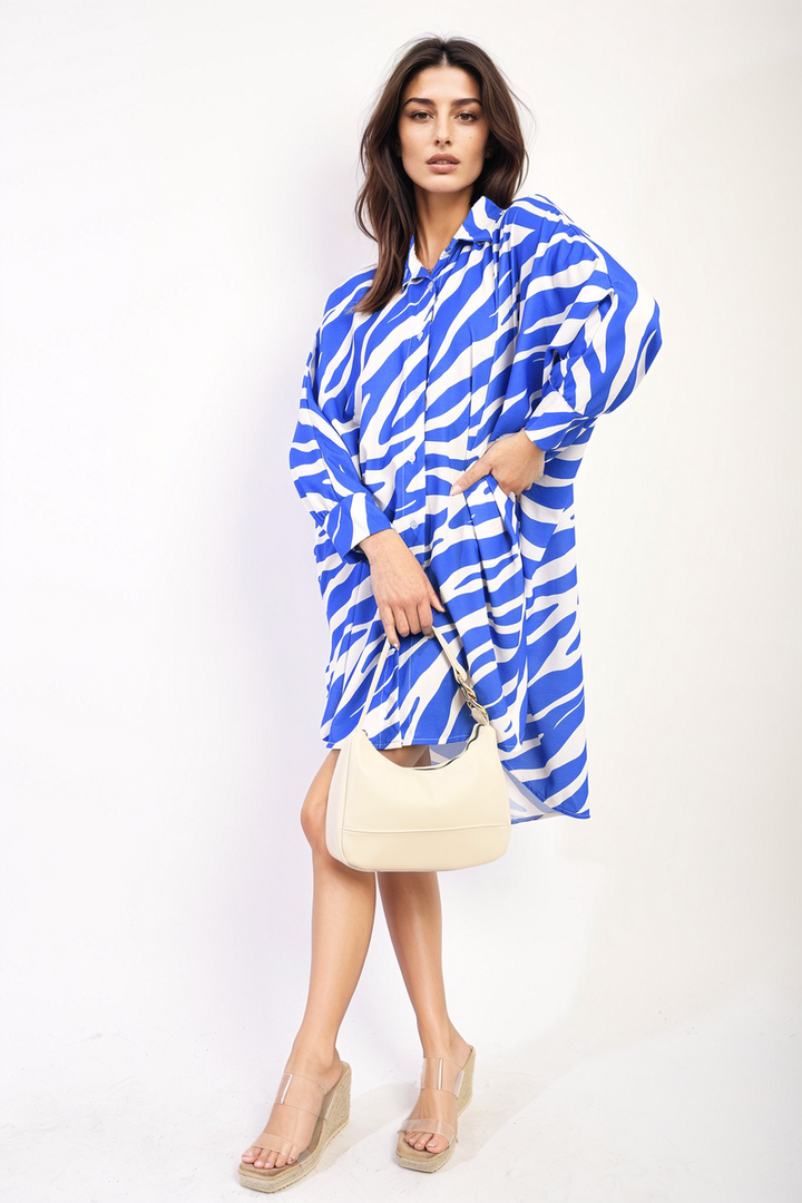 Woman in Zebra Print Oversized Button Down Shirt Dress, holding a white purse, showcasing a stylish and comfortable look for Holiday Clothes UK shoppers.